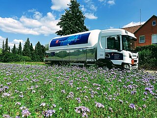 Westfalengas Lkw hinter Blumenwiese beliefert Haus mit Flüssiggas
