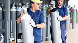 Zwei Westfalen-Mitarbeiter tragen Gasflasche