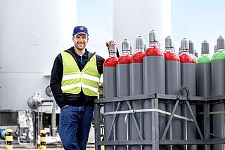 Westfalen-Mitarbeier in Arbeitskleidung neben Gasflaschen