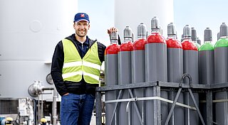 Westfalen Mitarbeiter steht in Schutzkleidung neben Gasflaschen