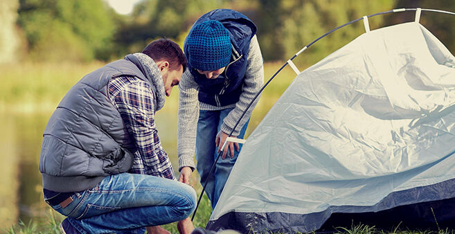 Vater und Kind bauen ein Zelt auf