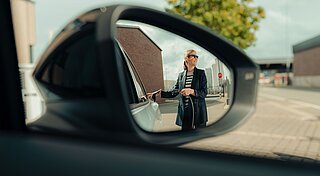 Mitarbeiterin lädt E-Auto auf Firmengelände