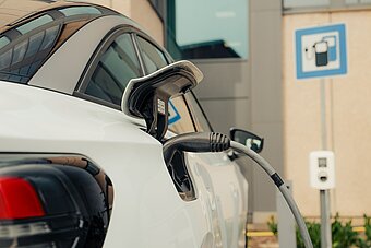 E-Auto lädt an Ladesäule auf Firmenparkplatz