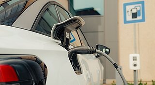 E-Auto lädt an Ladesäule auf Firmenparkplatz