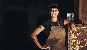 Schweißgase, Frau mit Schutzschürze in Schweißwerkstatt