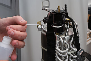 Bei der ADR-Prüfung wird mit Seifenlösung geprüft, ob alle Ventile dicht sind. Enstehen Bläschen tritt Gas aus – das Signal, dass sie ausgetauscht werden müssen.