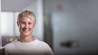 Lächelnde kurzhaarige Blondine im Büro