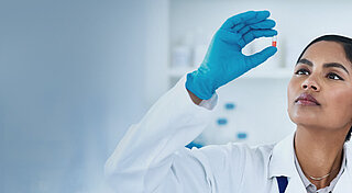 Frau im Labor prüft eine Pille