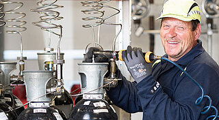 Mann in Arbeitskleidung an Gasflaschen
