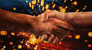 Schweißgase, Handschütteln vor sprühenden Funken im Hintergrund