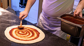 Pizzabäcker bereitet gerade Pizza vor