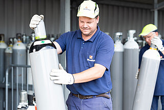 Westfalen-Mitarbeiter in Arbeitskleidung mit einer Gasflasche auf dem Werksgelände