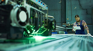 Mitarbeiter beim Laserschneiden an Maschine