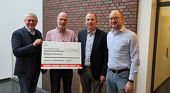 Menschen bei einer Spendenscheckübergabe