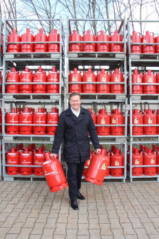 Dr. Tim Fronholt mit Propanflaschen der Marken Westfalengas und Globalgas.