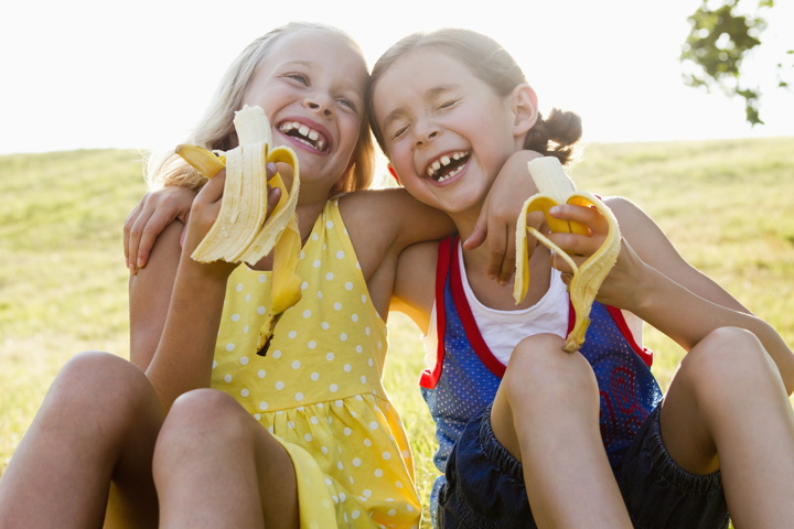 Bananenreifung. Kinder lachen und essen Banane